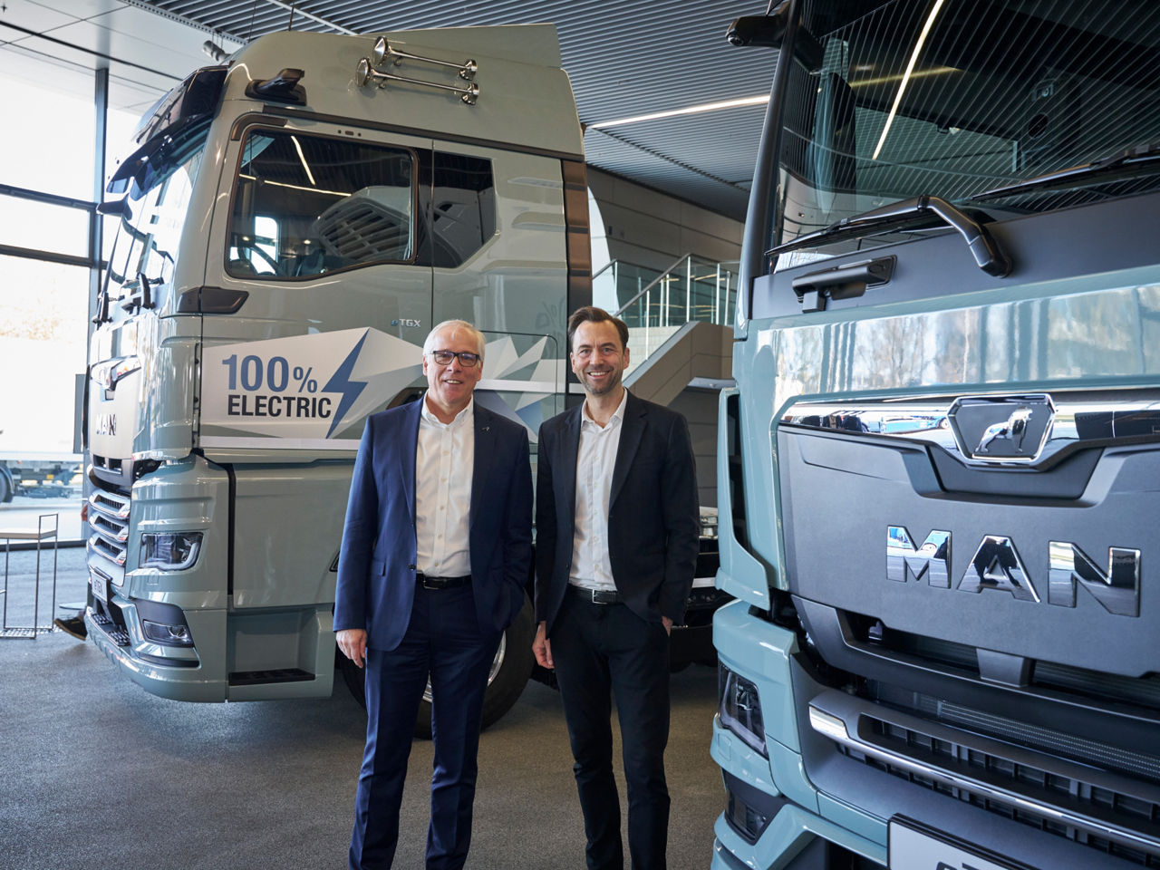 2 men in front of trucks